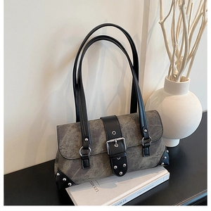 Detail of studded motorcycle shoulder bag with vintage silver buckle and rivet accents