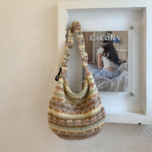 Detail of colorful striped fuzzy tote bag showing the thick plush texture on a white wall