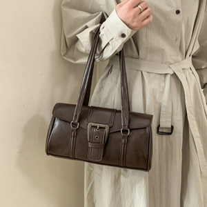 Close-up of a vintage dark brown leather underarm bag with a wide metallic buckle detail