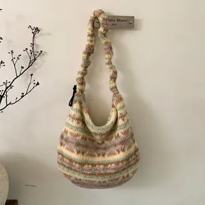 Detail view of colorful striped plush hobo bag with fuzzy texture and pleated shoulder strap