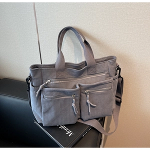 Détail du sac à main en velours côtelé gris-bleu montrant les deux poches avant