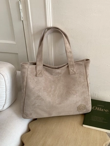 Minimalist beige suede tote bag for women showing a spacious interior and leather logo