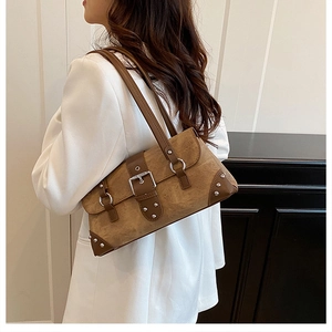 Detail of vintage brown shoulder bag featuring metallic rivets and buckle decoration