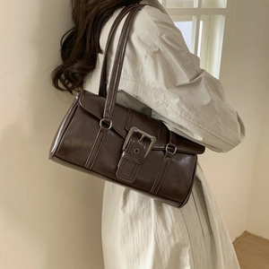Detail of dark brown vintage faux leather shoulder bag with metallic buckle accent
