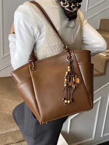 Grote donkerbruine tote bag voor dames met zijvak en bohemien kwastje als decoratie