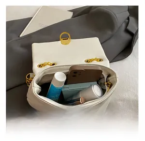 Interior view of white quilted chain bag showing capacity for phone and cosmetics