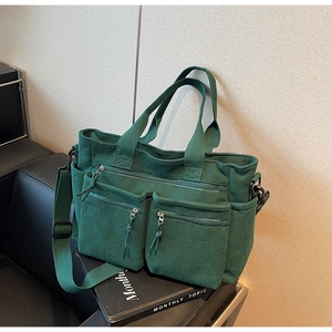 Vue détaillée du sac en velours côtelé vert foncé avec poches zippées et texture du tissu