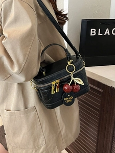 Quilted black leather crossbody box bag with cherry charm and gold zipper details