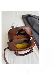 Innenansicht der braunen Leder-Bowlingtasche mit Handy, Regenschirm und Geldbörse