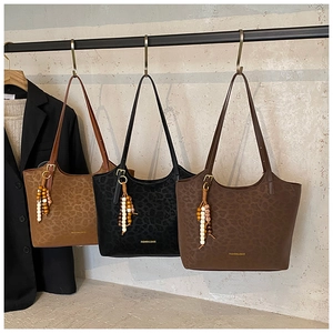 Détail du sac cabas léopard avec breloque en bois et lettrage doré de haute qualité