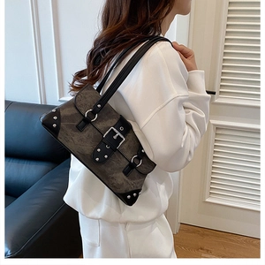 Close-up of vintage biker bag featuring punk metallic rivets and buckled strap details