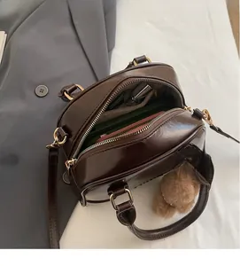 Deep coffee Boston bag interior view showing spacious capacity with plush bear charm