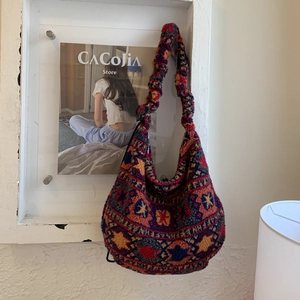 Close-up of bohemian style plush tote bag with vibrant red and blue knit patterns