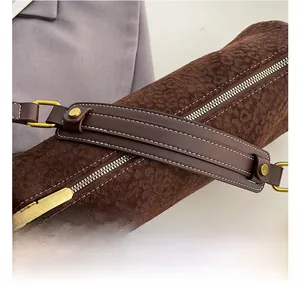 Detail of leopard print cylinder bag showing fine white contrast stitching and gold zipper