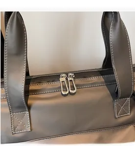 Détail de la double fermeture éclair en métal et coutures renforcées sur le sac de voyage