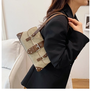 Detailed side view of vintage rivet shoulder bag in beige canvas and brown leather