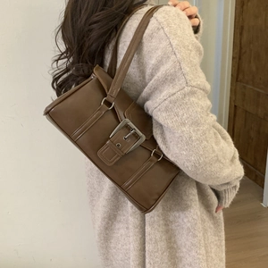 Deep brown faux leather baguette bag with large vintage buckle detail on a model