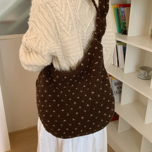 Detail of soft fuzzy brown tote bag with white heart patterns and plush shoulder strap