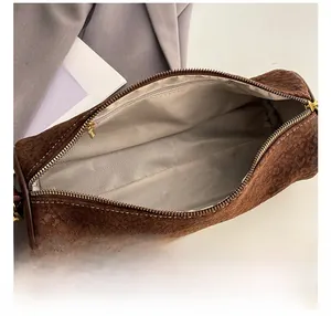 Macro shot of cylinder bag interior with gray chevron lining and golden metal zipper
