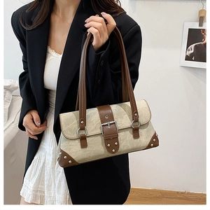 Chic rivet shoulder bag detail with green canvas and dark brown leather stitching