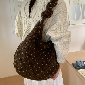Detail of soft fuzzy brown tote bag with beige dots worn with a cozy knit sweater