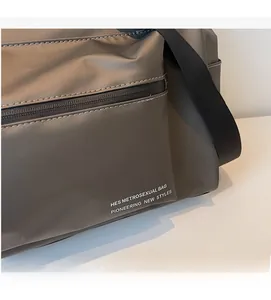 Détail du sac de voyage gris étanche avec poche zippée et large bandoulière noire