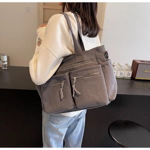 Détail du sac fourre-tout en velours côtelé gris foncé avec deux poches zippées et large bandoulière