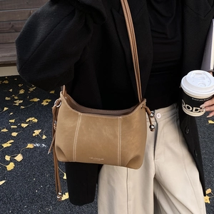 Detail of khaki frosted leather shoulder bag with white contrast stitching and bead drawstring