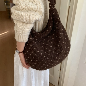 Macro shot showing thick brown faux shearling texture and cream polka dots on the hobo bag