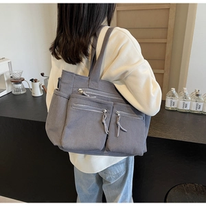 Vue détaillée d'un sac cabas en velours côtelé gris avec plusieurs poches zippées pratiques