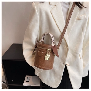 Detail of vintage brown bucket bag with silk scarf handle and golden lock ornaments