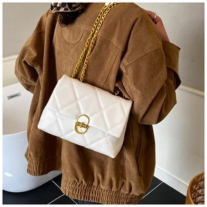 Close-up of white quilted leather bag with gold chain and oval metal buckle detail