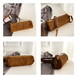 Detail of brown cylinder crossbody bag with contrast white stitching and gold hardware