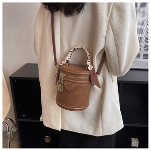 Detail of vintage brown bucket bag with leopard print silk scarf and gold hardware