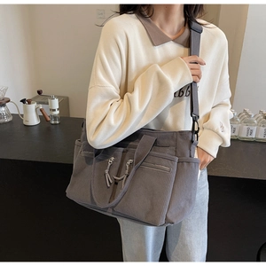 Détail du sac fourre-tout en velours côtelé gris foncé avec poches zippées et texture
