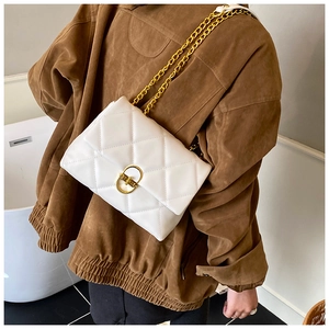 Detail of white quilted leather bag with gold chain strap and elegant twist lock on model