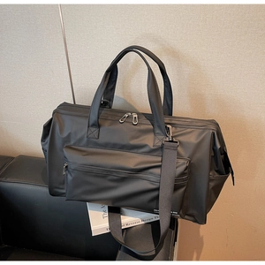 Détail du grand sac de voyage noir imperméable avec doubles poignées et poches latérales