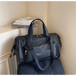 Détails du sac de voyage noir avec poignées renforcées et bandoulière amovible