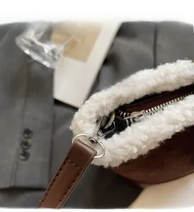 Detalle de bolso tipo cubo vintage con herrajes plateados y ribete de piel sintética blanca
