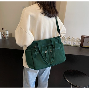 Vue détaillée du sac cabas en velours côtelé vert foncé avec poches zippées multiples