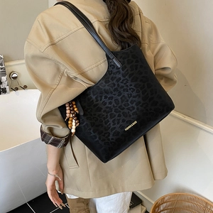 Detail of black leopard texture tote bag with beads and golden fashion lettering