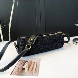 Macro detail of leopard texture fabric and leather strap with white stitching on bag