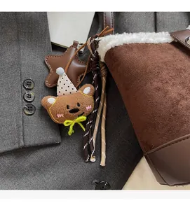 Detalle de dije de oso de peluche con estrella de cuero en bolso tipo cubeta