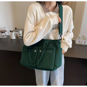 Détail du sac cabas en velours côtelé vert foncé avec poches et bandoulière réglable