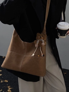 Borsa hobo in pelle scamosciata marrone con cuciture bianche e ciondolo a forma di orso