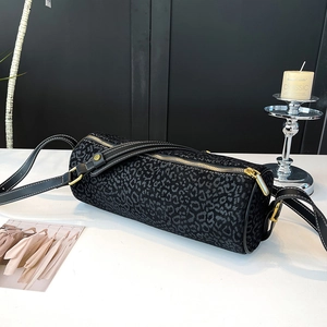 Detail of leopard print cylinder bag with gold zipper and contrast stitching strap