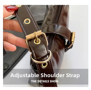 Détail de la bandoulière en cuir verni marron foncé avec boucle en métal doré