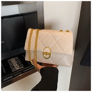 Detailed view of cream quilted shoulder bag with gold chain strap and metal clasp