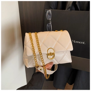 Detail of cream quilted leather handbag with gold chain strap and metal clasp lock