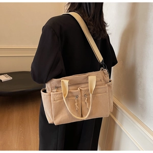 Détail du sac fourre-tout en velours côtelé à plusieurs poches avec bandoulière large